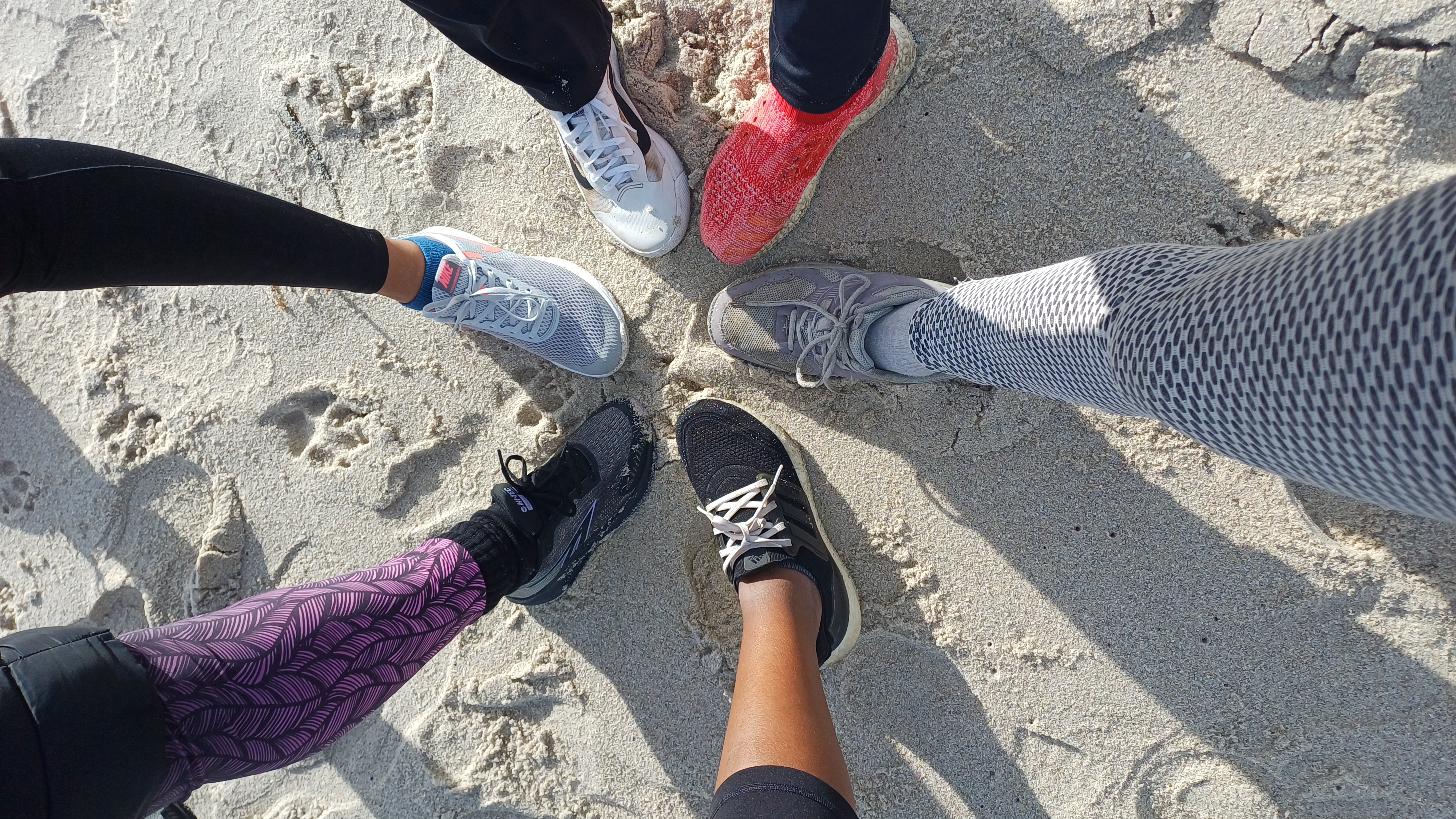 People's feet in sand - the opposite of loneliness